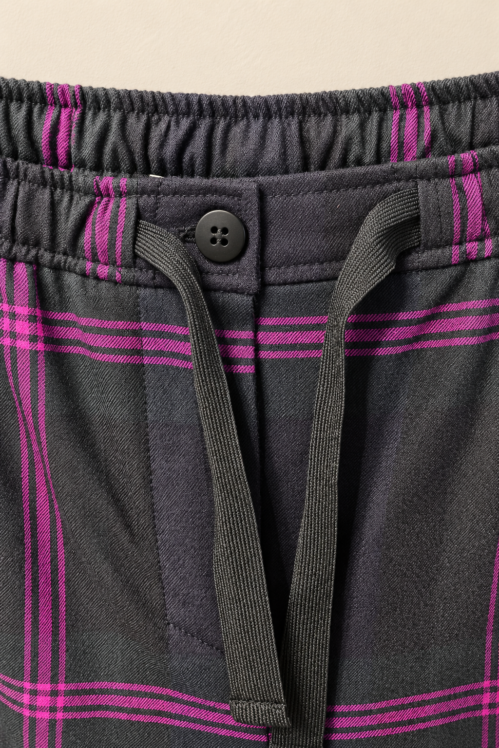 Detalle de la cintura elástica, el cordón ajustable y el botón del pantalón Paola.